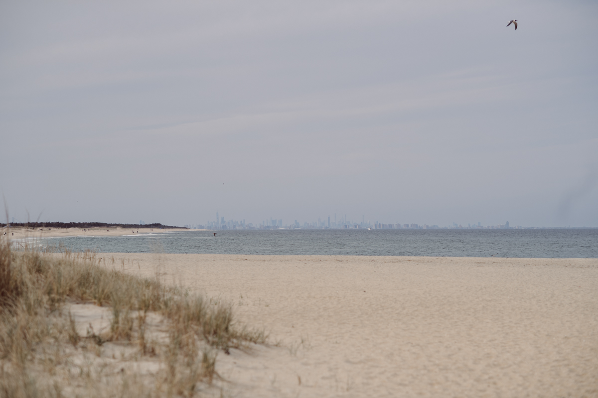 Perfect day would look like this, I said admiring the beach, the landscape and the amazing colors that I was looking out in the horizon. Sky, sea, sand looked as if they were painted in pastel blues, beige, and white. Wind moved, hair dancing, it was going to be fabulous engagement session with Becca and Dan! I fell in love with Sandy Hook Beach, and loved my awesome clients that follows all my weird, silly and sometime awkward directions/posing. My favorite out of Becca and Dan's Sandy Hook engagement session is the one that I got inspired by Wes Anderson's movie "Moonlight Kingdom"! Becca and Dan's Sandy Hook Beach NJ engagement by Karis. Hey Karis is Hudson Valley, Garrison NY and NJ, Fun Weddings and Intimate Elopements Photographer.
